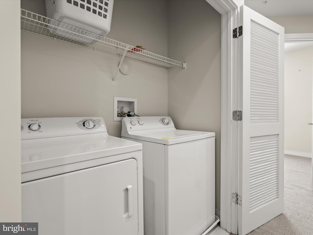 clothes washing area with light carpet and washer and clothes dryer