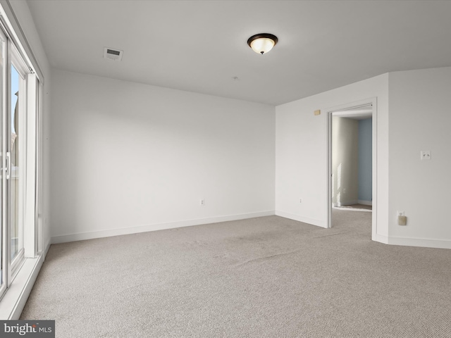 spare room featuring light colored carpet