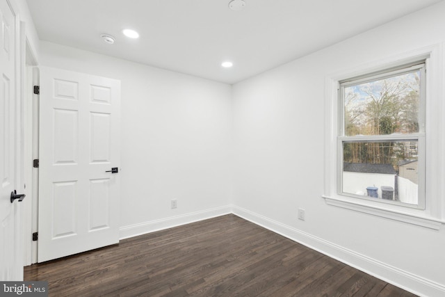 unfurnished room with baseboards, dark wood-style flooring, and recessed lighting