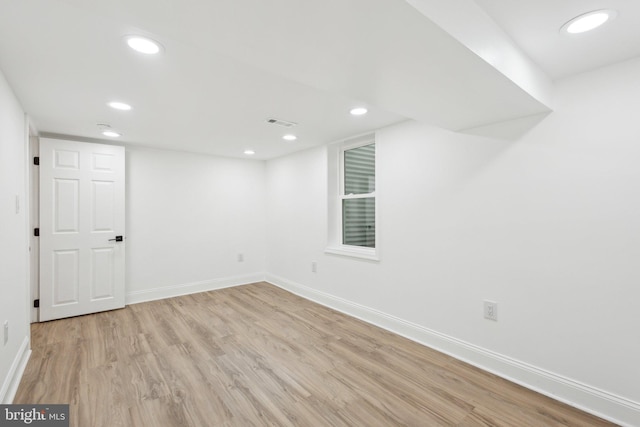 finished basement with light wood finished floors, visible vents, baseboards, and recessed lighting