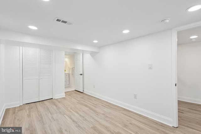 finished below grade area featuring light wood finished floors, baseboards, visible vents, and recessed lighting