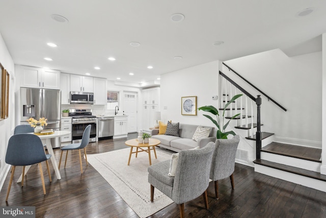 living room with recessed lighting, visible vents, dark wood finished floors, and stairway