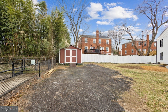 view of yard featuring a storage shed, an outdoor structure, and fence