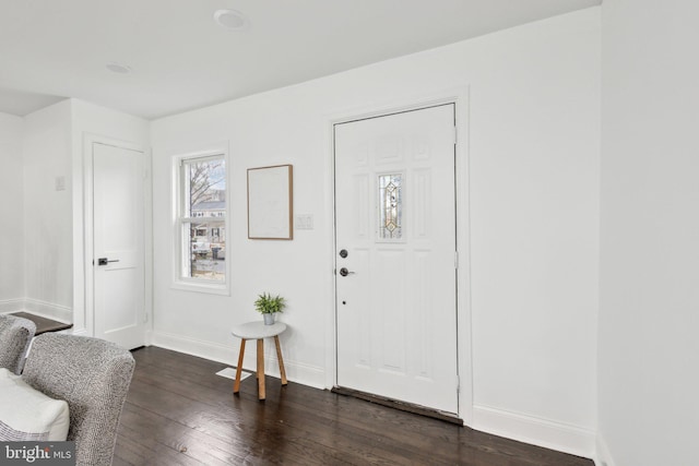 foyer entrance with dark wood-style floors and baseboards