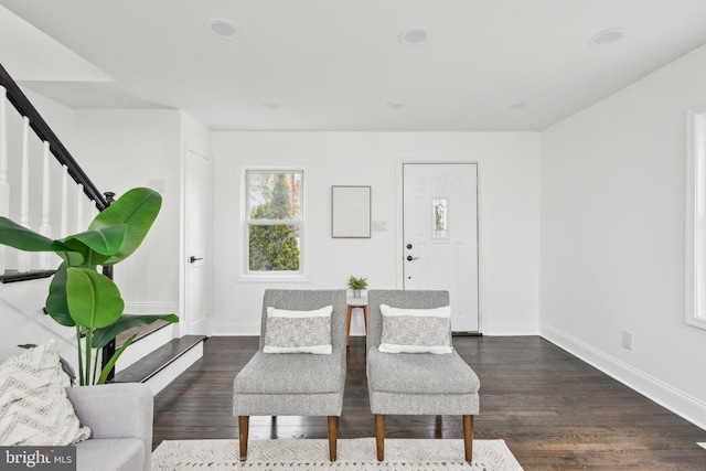 living area featuring dark wood-style floors, stairway, and baseboards