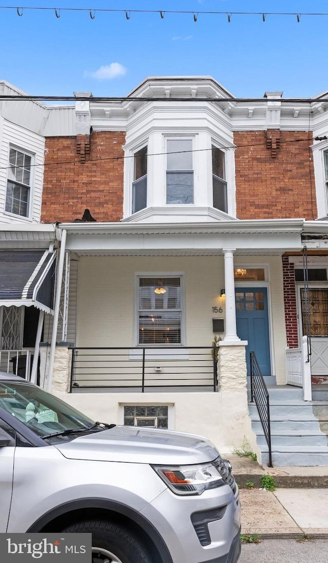 townhome / multi-family property featuring covered porch