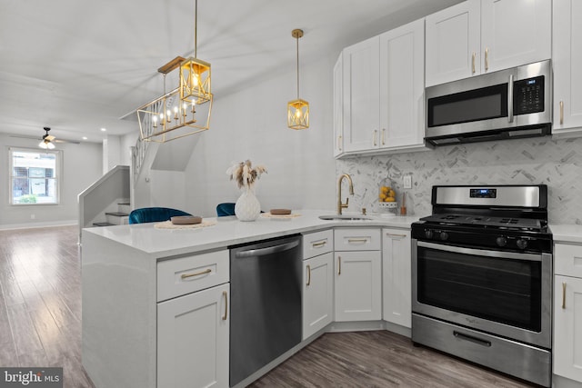 kitchen featuring white cabinetry, sink, pendant lighting, and stainless steel appliances