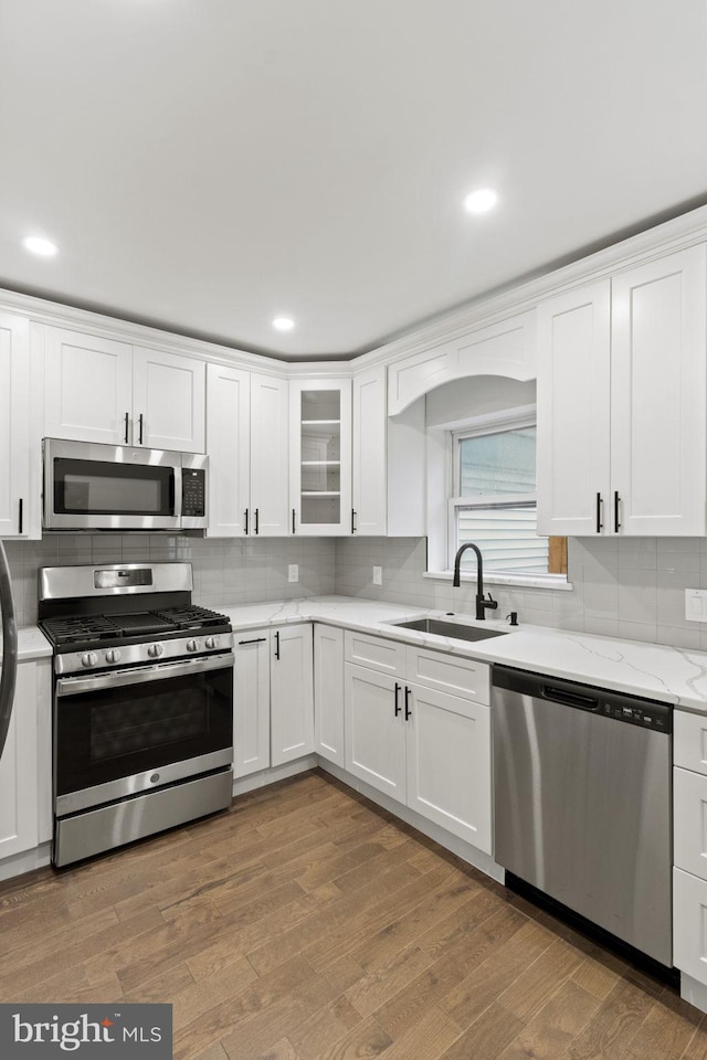 kitchen featuring white cabinetry, stainless steel appliances, sink, and hardwood / wood-style flooring