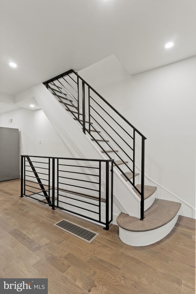 stairs featuring hardwood / wood-style flooring