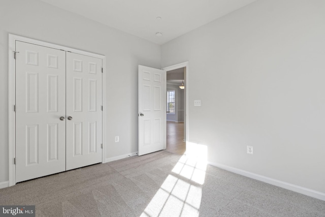 unfurnished bedroom with a closet and light carpet