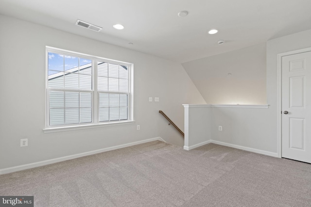 carpeted empty room with lofted ceiling