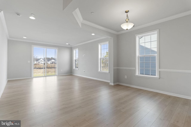 empty room with crown molding and light hardwood / wood-style floors