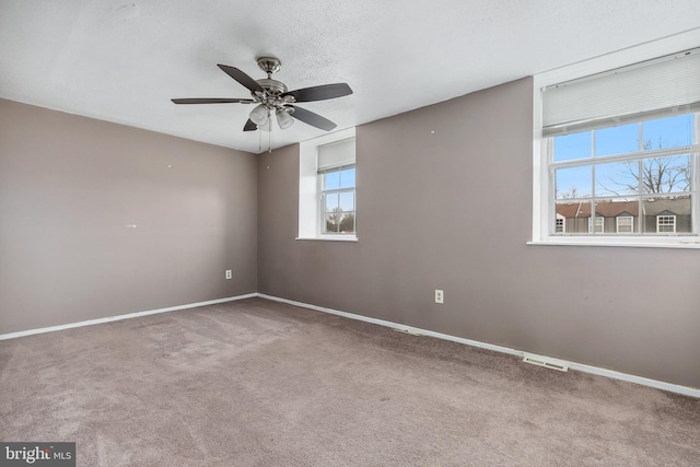 unfurnished room with ceiling fan, carpet floors, and a textured ceiling