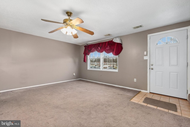 carpeted entrance foyer with ceiling fan and a textured ceiling