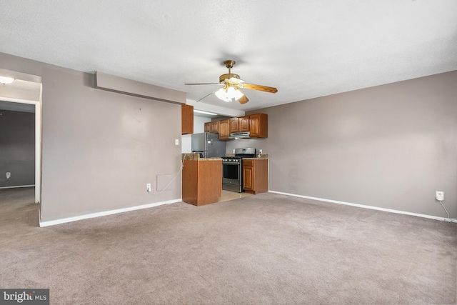 kitchen featuring exhaust hood, light colored carpet, ceiling fan, stainless steel appliances, and a textured ceiling