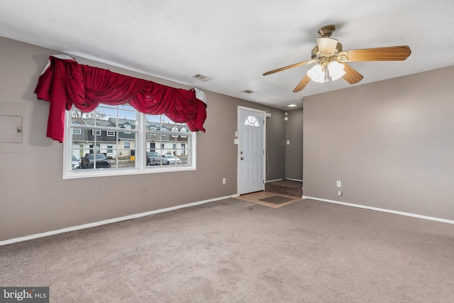 interior space with ceiling fan, carpet floors, and a textured ceiling