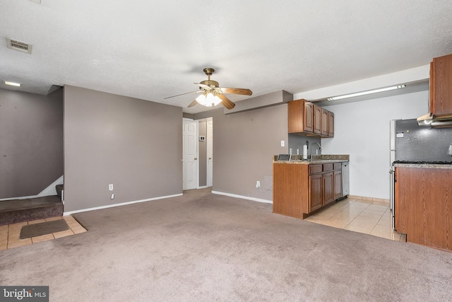 kitchen with sink, light carpet, a textured ceiling, and ceiling fan