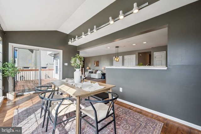 dining area featuring hardwood / wood-style flooring and vaulted ceiling