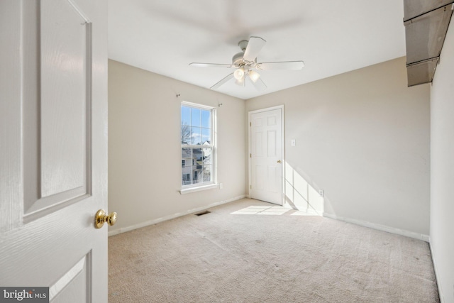 carpeted spare room featuring ceiling fan