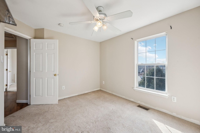 unfurnished room featuring light colored carpet and ceiling fan