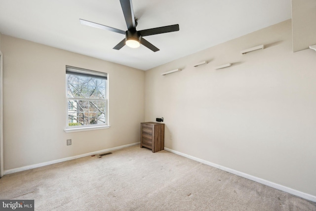 spare room featuring ceiling fan and light carpet