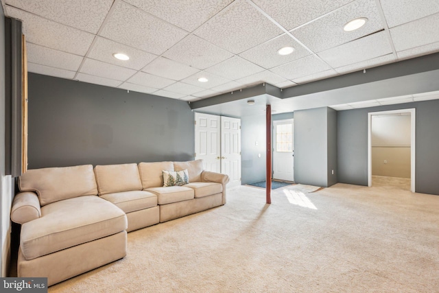 unfurnished living room with carpet floors and a paneled ceiling