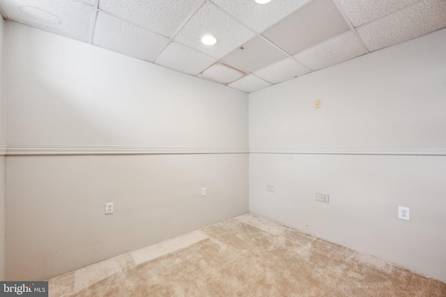 carpeted spare room featuring a paneled ceiling