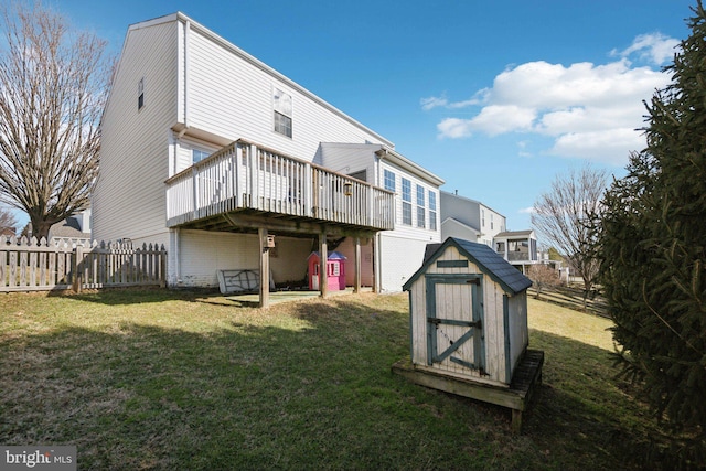 back of property with a yard, a deck, and a storage unit