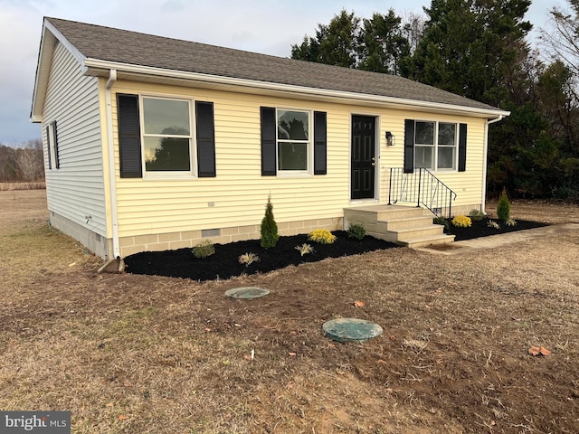 view of front facade with crawl space and a shingled roof