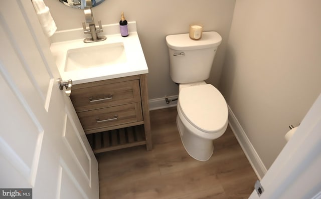 bathroom featuring vanity, hardwood / wood-style flooring, and toilet