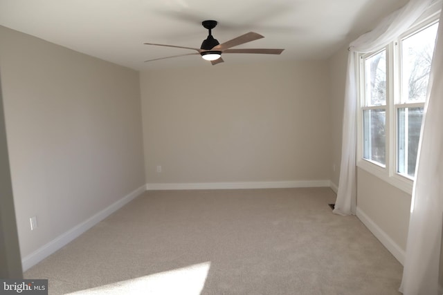 unfurnished room with light colored carpet and ceiling fan