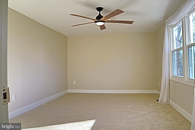 carpeted spare room with a wealth of natural light and ceiling fan