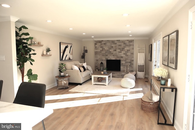 living room featuring ornamental molding, a brick fireplace, and light wood-type flooring