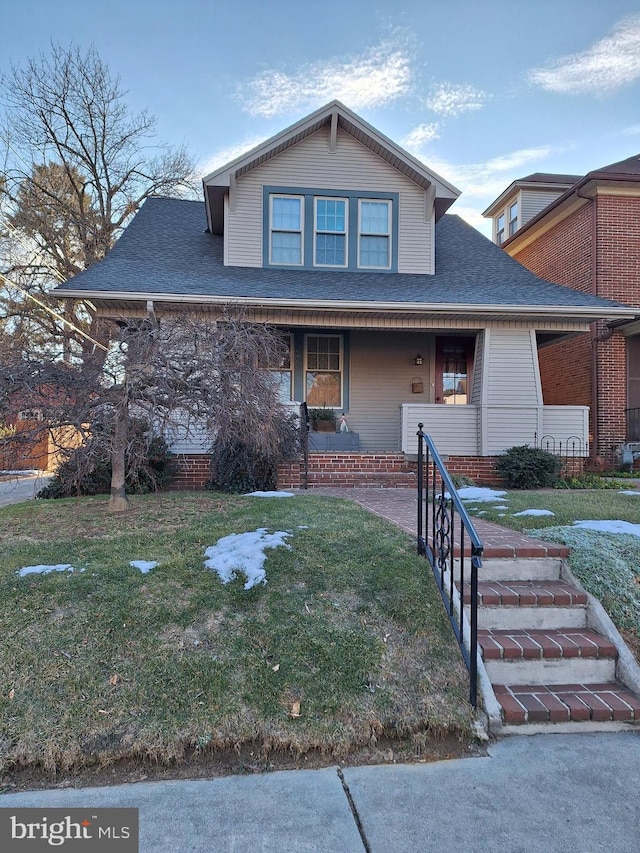 view of front of property with covered porch and a front yard