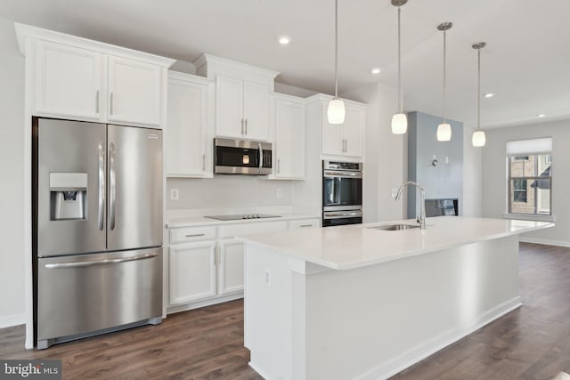 kitchen featuring an island with sink, appliances with stainless steel finishes, sink, and white cabinets