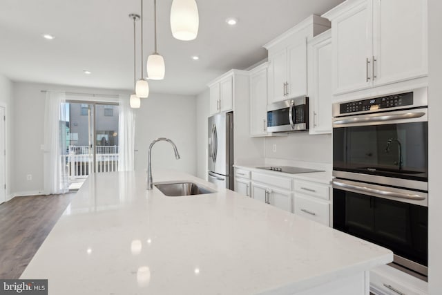 kitchen with sink, decorative light fixtures, appliances with stainless steel finishes, light stone countertops, and white cabinets