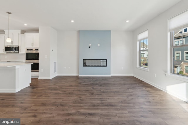 unfurnished living room with dark hardwood / wood-style flooring