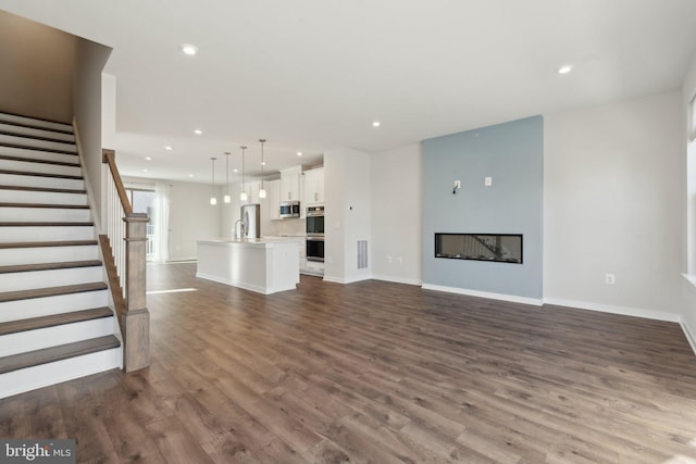 unfurnished living room with sink and dark hardwood / wood-style flooring