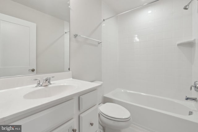 full bathroom featuring vanity, tiled shower / bath, and toilet