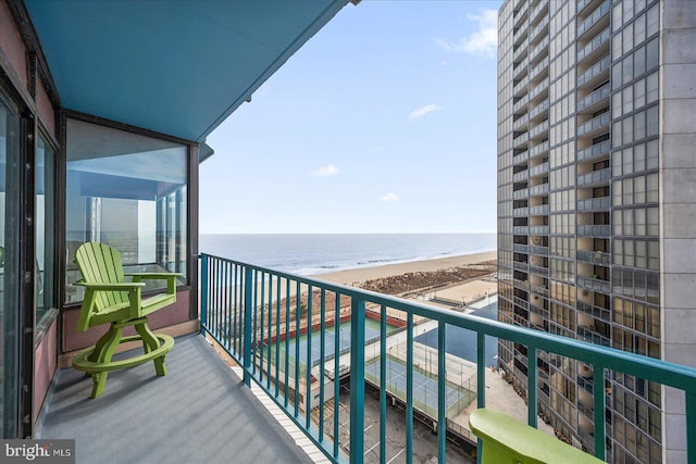 balcony featuring a water view and a beach view