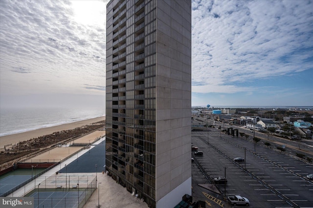 view of building exterior with a water view and a beach view