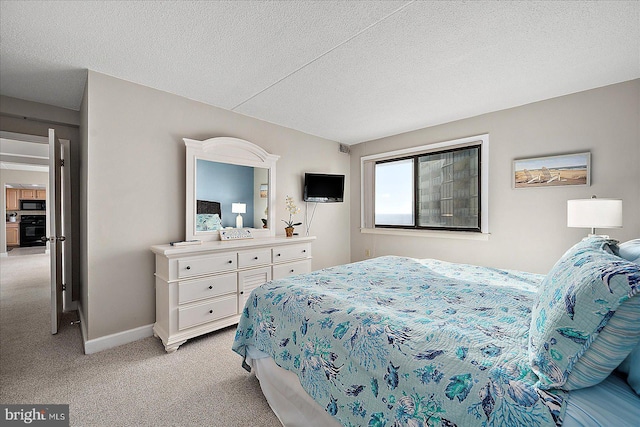 bedroom featuring light carpet and a textured ceiling