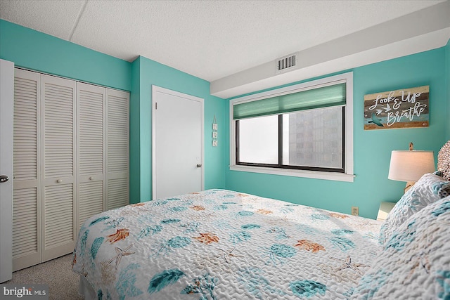 carpeted bedroom with a closet and a textured ceiling