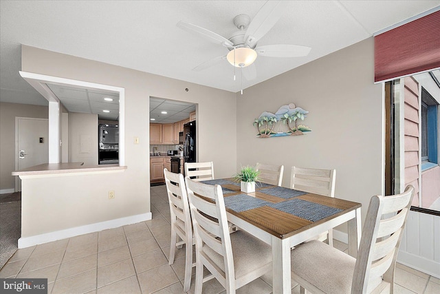 tiled dining room featuring a drop ceiling and ceiling fan