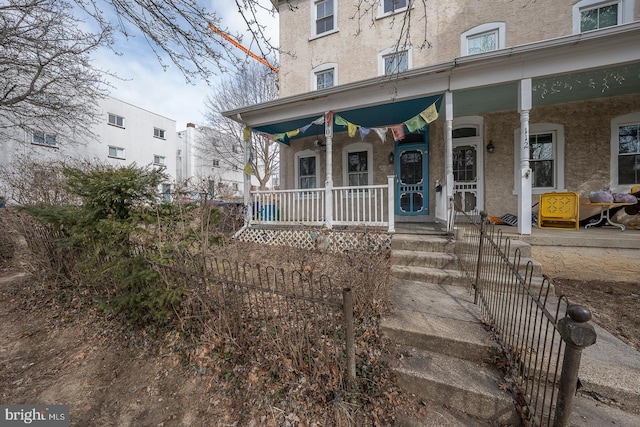 doorway to property with covered porch and stucco siding