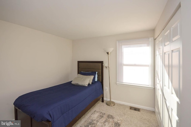 bedroom with light colored carpet, visible vents, and baseboards