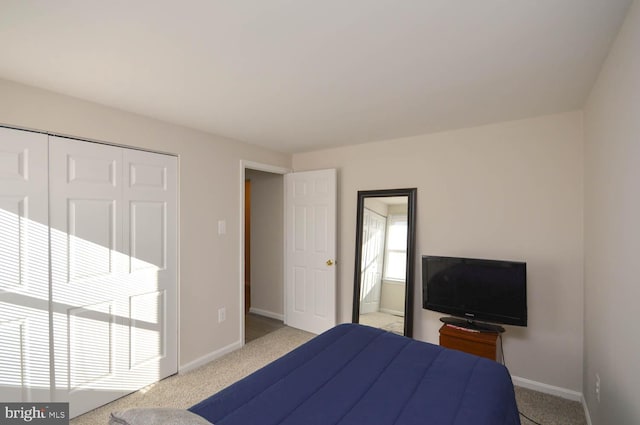 unfurnished bedroom with baseboards, a closet, and light colored carpet