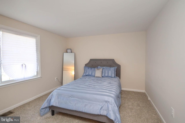 bedroom with visible vents, light carpet, and baseboards