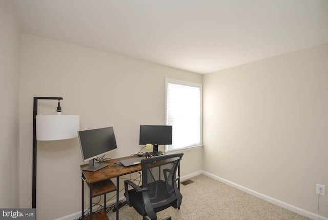 carpeted office space with visible vents and baseboards