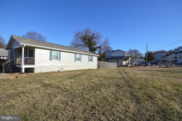 view of home's exterior featuring a lawn and fence